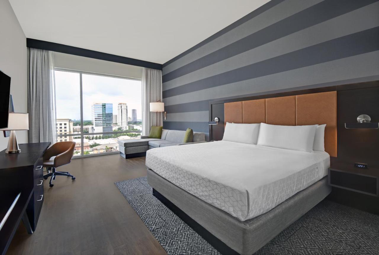 Suite mit Kingsize-Bett und Blick auf die Skyline – obere Etage